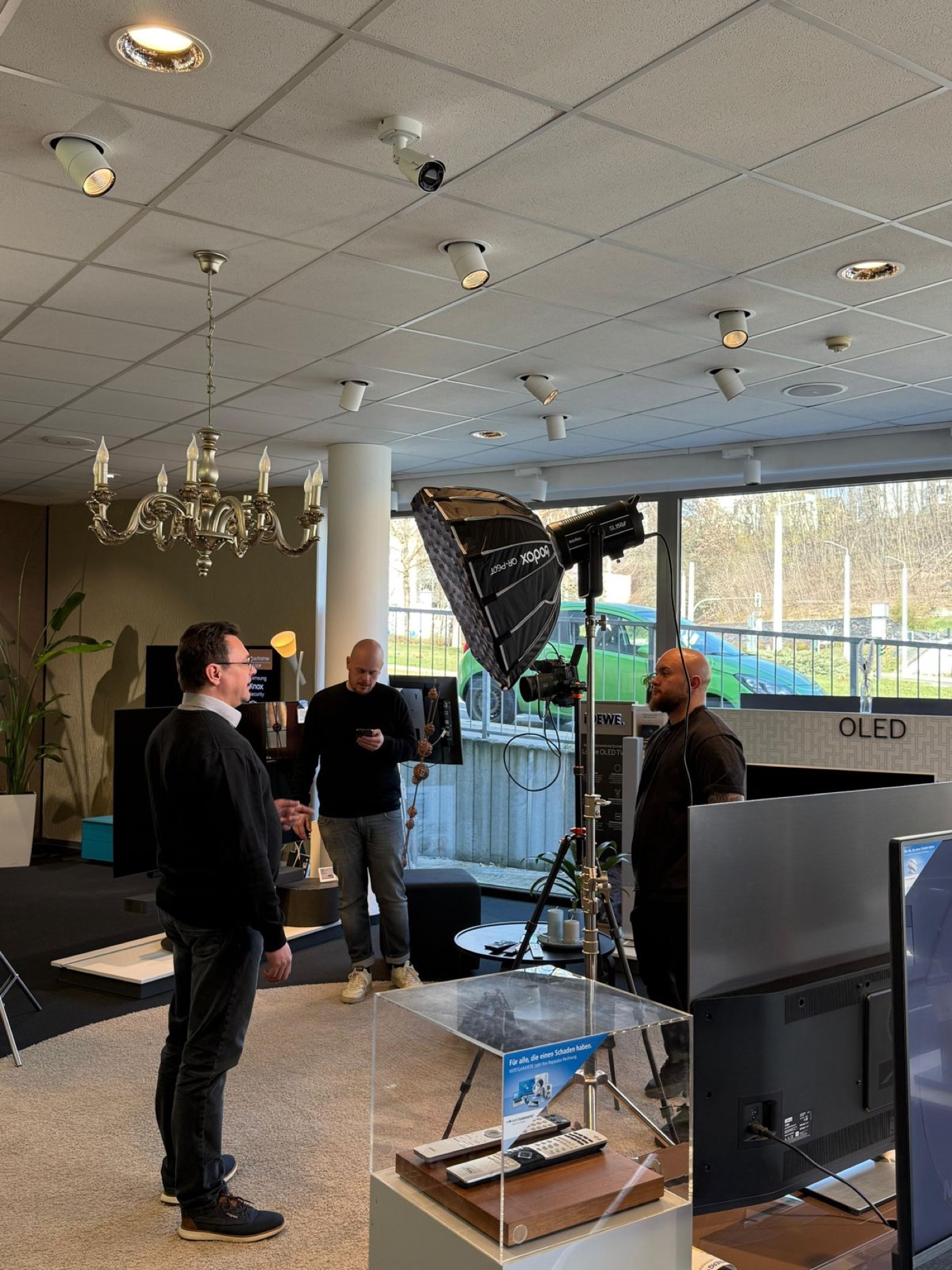 Produktionsteam mit Kamera und Lichtsetup im Ladengeschäft eines Fachhändlers
